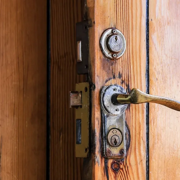 Cabin door handle, brass and lock plate against vertical wood grain